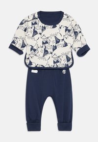Kosekledningssett for baby laget av bomull, med en kremfarget topp med marineblå dyremotiver og marineblå bukser med oppbrettede ankler og logo.