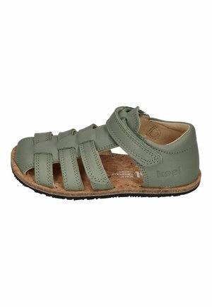 Grüne Kinderledersandale mit mehreren Riemen, Korkfußbett, schwarzer Sohle und Klettverschluss am Knöchel, Seitenansicht.