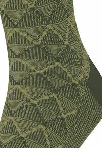 Olivenfarbene gemusterte Socken mit einem geometrischen Design aus strukturierten Linien und Formen, gefertigt aus einem dehnbaren Stoff.