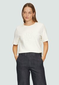 Witte t-shirt met korte mouwen en een geborduurd "DRY AMY" ontwerp, gecombineerd met donkere grijze op maat gemaakte broeken. Glad materiaal, ontspannen pasvorm.