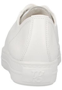 Chaussure décontractée en cuir blanc avec une finition texturée, dos arrondi et design minimaliste. Elle dispose d'une semelle en caoutchouc plate avec un logo en relief.