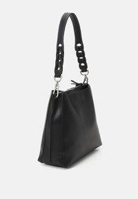 Svart läderhandväska med en strukturerad form, utrustad med ett texturerat flätat handtag och silverfärgade detaljer. Dragkedja upptill.