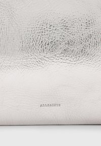 Zilveren leren tas met een gestructureerd oppervlak, voorzien van een subtiele merkgravure "ALLSAINTS" aan de onderkant. Rechthoekige vorm.