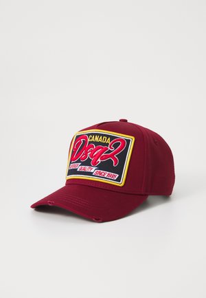 Casquette de baseball bordeaux avec une couronne structurée, ornée d'un patch logo brodé multicolore et de détails décolorés sur le bord.
