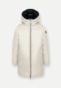 Dlhý béžový páperový kabát s vysokým golierom, zipsovými prednými otvormi a kontrastnou tmavomodrou podšívkou kapucne. Na ľavom rukáve sa nachádza kruhové logo.