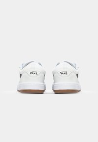 Bijele kožne tenisice sivo-dijagonalnog panela, podstavljenim ovratnikom, gumiranim potplatima i "VANS" logotipom na peti. Glatka tekstura i zaobljen oblik.