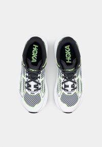 White and black athletic shoes with mesh upper, green accents, and black laces. Features reinforced heel and branded insoles.