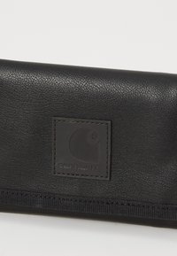 Zwarte leren portemonnee met een gestructureerde afwerking, voorzien van een Carhartt-logo en een contrasterende stiknaad langs de rand.