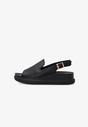 Sort åben tå slingback-sandal med tekstureret overlæder, polstret sål, tyk sort platform og guldlåssestrop på hvid baggrund.