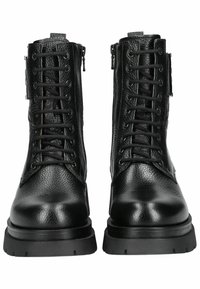 Bottines en cuir noir avec une finition texturée, présentant un laçage à l'avant, une fermeture éclair sur le côté et une semelle en caoutchouc épaisse.