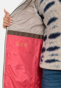Letvæg puffy jakke med en beige yderside og lys pink foring, med vandafvisende, vindtæt og dunfri ikoner.