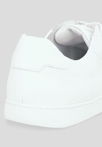 Białe sneakersy z gładką, teksturowaną skórzaną cholewką, zaokrąglonym obcasem, detalami przeszycia i płaską podeszwą. Posiadają wyściełany kołnierz dla wygody.