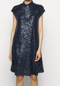Navy blue sequined dress with a mandarin collar and cap sleeves, featuring a flared silhouette and a textured, shimmering surface.