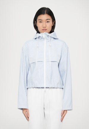 Valge ja helesinise triibuline lühendatud kapuutsiga dressipluus, millel on paelaga kapuuts, kaks esist taskut ning pikad varrukad lahtise lõikega.