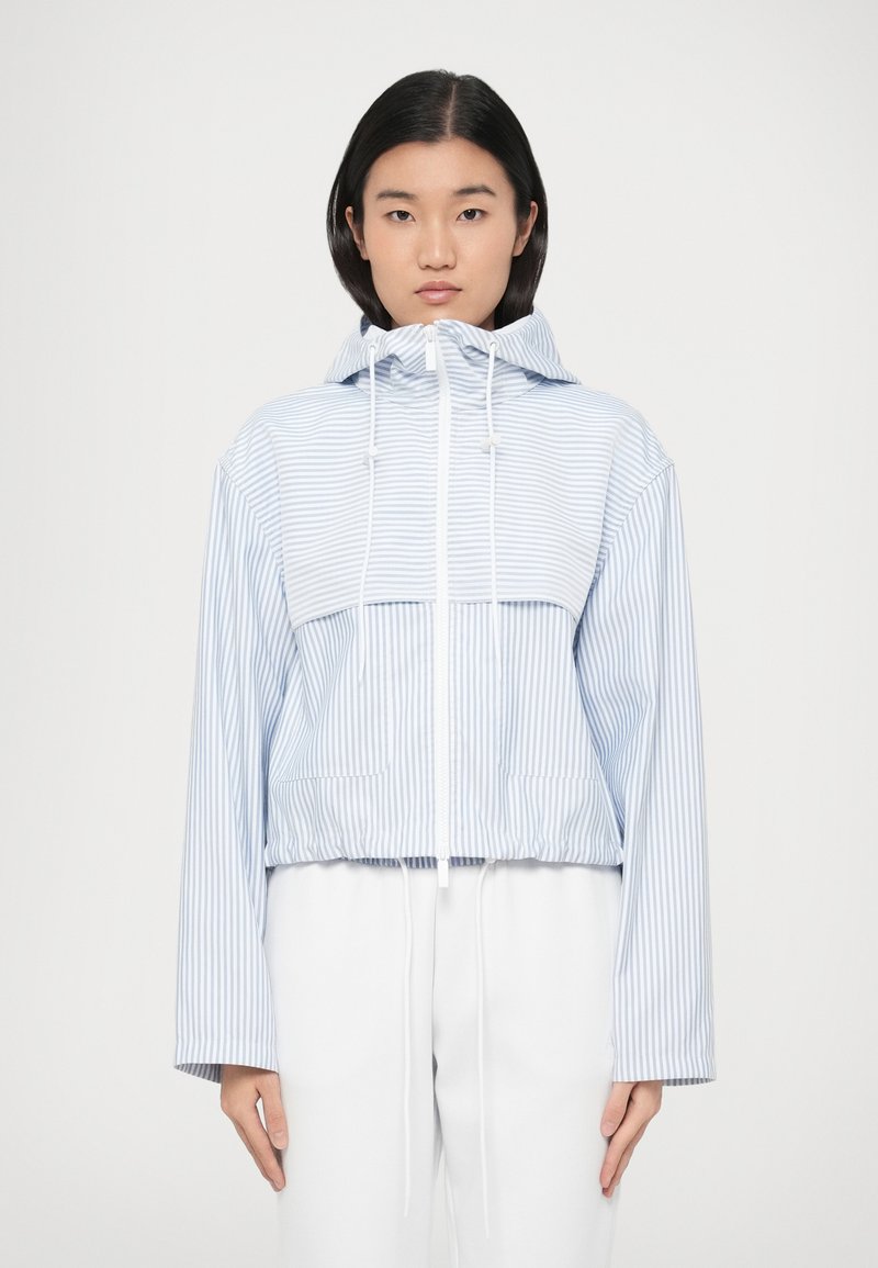 Ριγωτό cropped φούτερ σε ανοιχτό μπλε και λευκό, με κουκούλα με κορδόνι, δύο μπροστινές τσέπες και μακριά μανίκια με άνετη εφαρμογή.