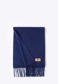 Navy blue wool scarf with fringed edges, featuring a tan leather label. Soft texture and rectangular shape, partially folded.