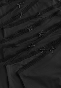 Juodas audinys su lygiu paviršiumi, puošiamas keliomis nėrinių juostelėmis ir mažomis juodomis juostelėmis. Dizainas yra vienodas ir ritmiškas.