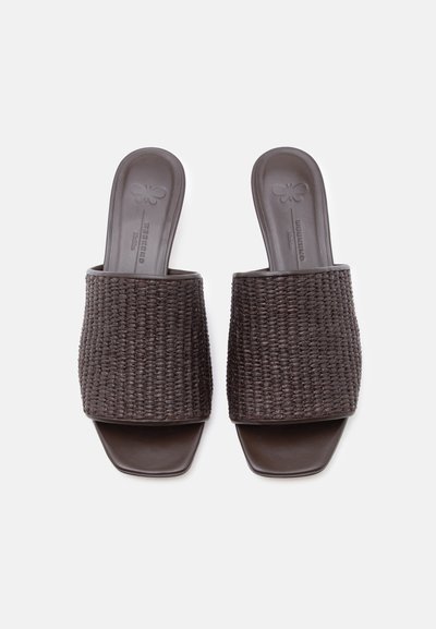 Καφέ υφαντές σανδάλια με φαρδιές λουρίδες και τετράγωνο σχέδιο στη μύτη, εμφανιζόμενα από πάνω σε λευκό φόντο.