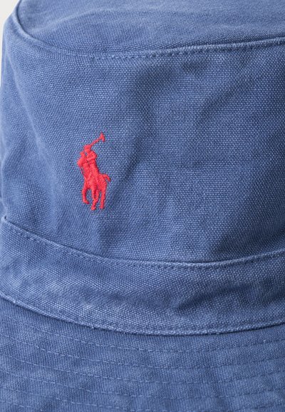 Μπλε καπέλο τύπου bucket με κόκκινο κεντητό λογότυπο ενός αναβάτη πόλο πάνω σε άλογο που σαρώνει με μαλέτα.