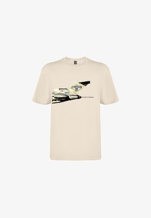 Beiges T-Shirt mit einer Grafik eines Flugzeughecks mit den Texten "Beastie Boys" und "No Sleep Til Brooklyn" auf der Vorderseite.