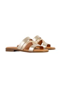 Metallisch goldene Sandalen mit zwei gekreuzten Riemen und offenem Zehendesign. Flache Sohle mit braunem Untergrund und glatter Textur.