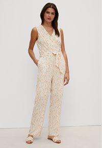 Jumpsuit bez rękawów z lekkiego materiału w pomarańczowy i kremowy wzór, z zamkiem kopertowym i związanym w pasie dla luźnego dopasowania.