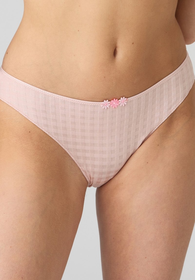 Pink cotton bikini with a textured grid pattern and floral embroidery detail at the hip. Soft fabric, low-rise design, smooth edges.