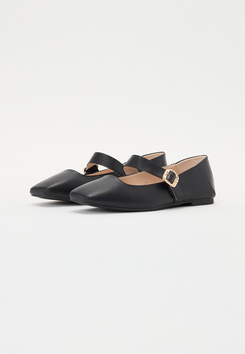 Ballerine nere con punta affusolata, caratterizzate da un cinturino incrociato e una fibbia con dettagli dorati, realizzate in pelle liscia. Suola piatta.