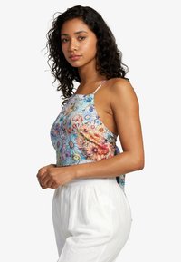 Floral-patterned sleeveless top in pastel colors with thin straps, featuring a loose fit and a rounded hem. Lightweight fabric texture.