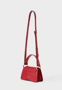 Κόκκινη δερμάτινη τσάντα ώμου με επάνω λαβή, μακρύ ρυθμιζόμενο λουρί, επίχρυσα μεταλλικά στοιχεία και το λογότυπο της Coccinelle στο μπροστινό καπάκι.