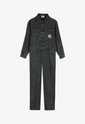 Dark gray long-sleeve jumpsuit with front zipper, two chest pockets, two side pockets, and a small square logo patch on the left chest pocket.