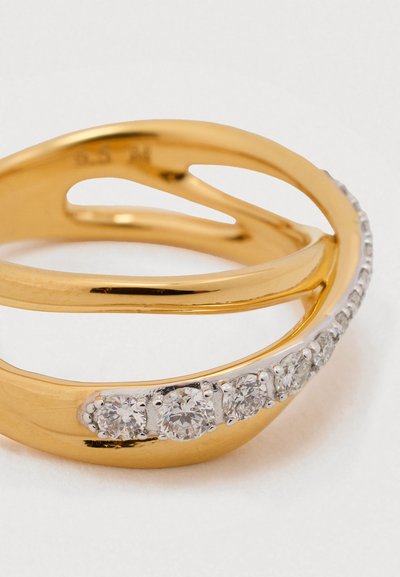 Auksinis žiedas su suktais raštais, turintis mažų, skaidrių apvalių akmenukų, įstatytų vienoje pusėje, lygia metaline danga ir poliruota tekstūra.