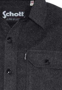 Dunkelgraue Wolljacke mit Knöpfen, schwarzen Knöpfen, einer geschlossenen Brusttasche und einem Schott N.Y.C. Markenlabel im Kragen und auf der Tasche.