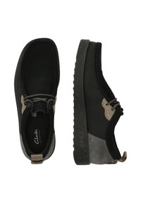 Black shoes with a mesh and suede upper, featuring a gray accent, rounded toe, textured sole, and a pull tab on the heel.