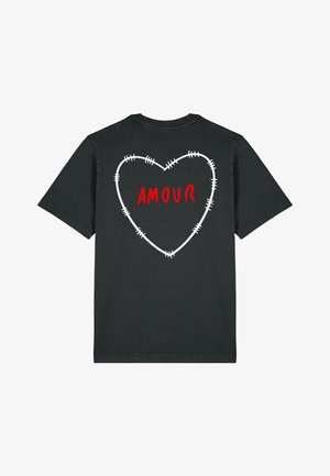 Zwarte katoenen T-shirt met een hartcontour en stiksels en het woord "AMOUR" in het rood, gecentreerd op de achterkant. Korte mouwen.