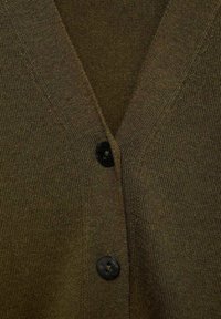 Brown knitted cardigan with a V-neck, featuring two black buttons and a textured fabric finish. Close-up view of the front.