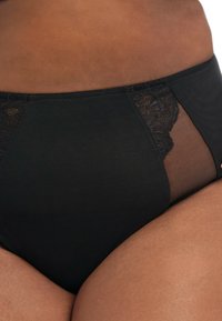 Hoch taillierte schwarze Panty mit Spitzenakzenten und transparenten Einsätzen, aus weichem, elastischem Material gefertigt. Klassisches Design mit bequemer Passform.