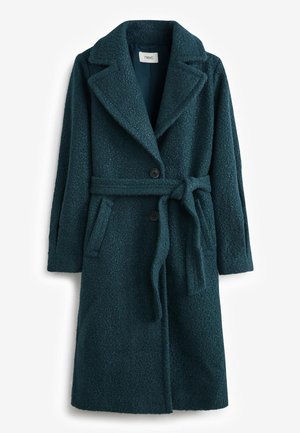 Manteau en laine texturée bleu sarcelle foncé avec larges revers, deux boutons, poches latérales et ceinture en tissu nouée à la taille.