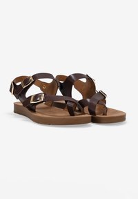 Sandali in pelle marrone con molteplici cinghie, fibbie dorate, suola piatta marrone e soletta testurizzata per il massimo comfort.
