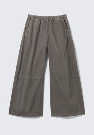 Pantalon à jambes larges de couleur grise douce, en tissu lisse, doté d'une ceinture élastique et de poches latérales, avec des coutures décoratives.