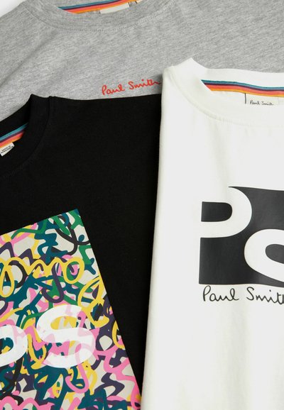 Tričko v šedej, čiernej a bielej farbe. Čierne tričko má farebnú grafiku; všetky majú branding "Paul Smith" a pruhované výstrihy.