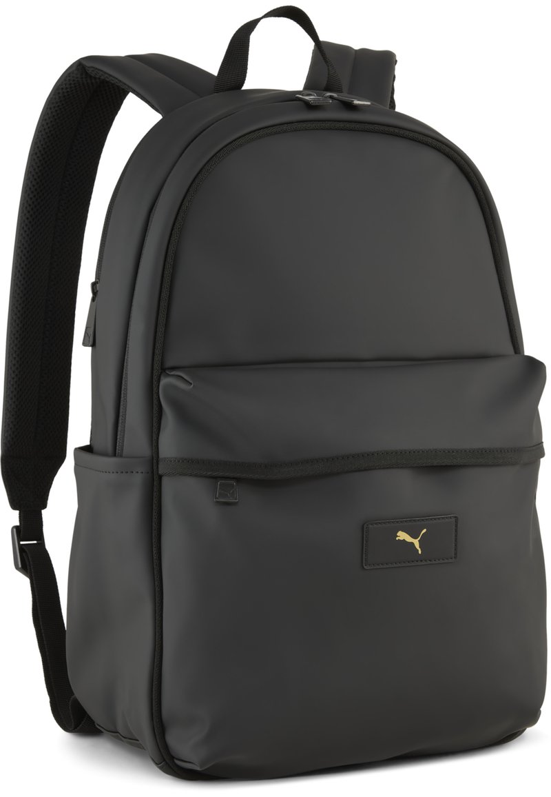 Rucsac negru cu un finisaj mat, neted. Include bretele căptușite, un buzunar frontal și un logo aurie Puma pe un patch rectangular.
