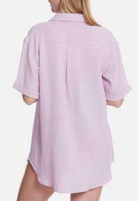 Lichtpaarse oversized shirt met een textuurstof, korte opgerolde mouwen en een lichtgebogen zoom met een rugplooi detail.