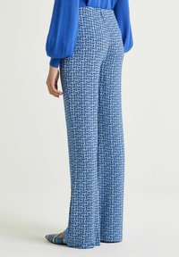 Pantaloni larghi con motivo in blu caratterizzati da un design geometrico con tonalità di blu, vita alta e una texture liscia.