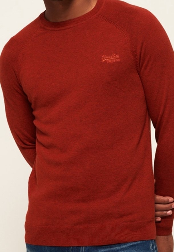 Maglione rosso lavorato a maglia con colletto rotondo e maniche raglan. Presenta un logo discreto sul petto e polsini e orlo a coste.