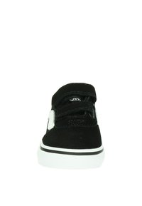 Zapatilla de ante negra con doble correa de Velcro, detalles en blanco y suela de goma. Diseño sencillo y bajo perfil con detalles de color en contraste.