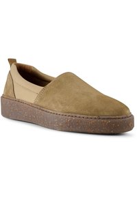 Mockasins i olivgrön mocka med en tan-färgad elastisk panel, en tjock brun spräcklig sula och en dragflik bak för enkel påtagning.