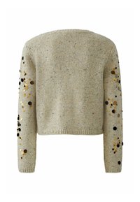 Gebreide trui in lichtbeige met gestructureerde textuur, voorzien van decoratieve gouden en zwarte pailletten langs de mouwen. Korte pasvorm.