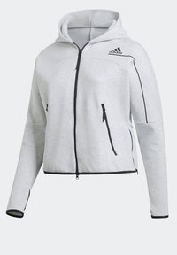 Sweat à capuche Adidas gris clair avec fermeture éclair noire intégrale, capuche, poches latérales zippées et détails de passepoil noir sur les manches et l’ourlet.