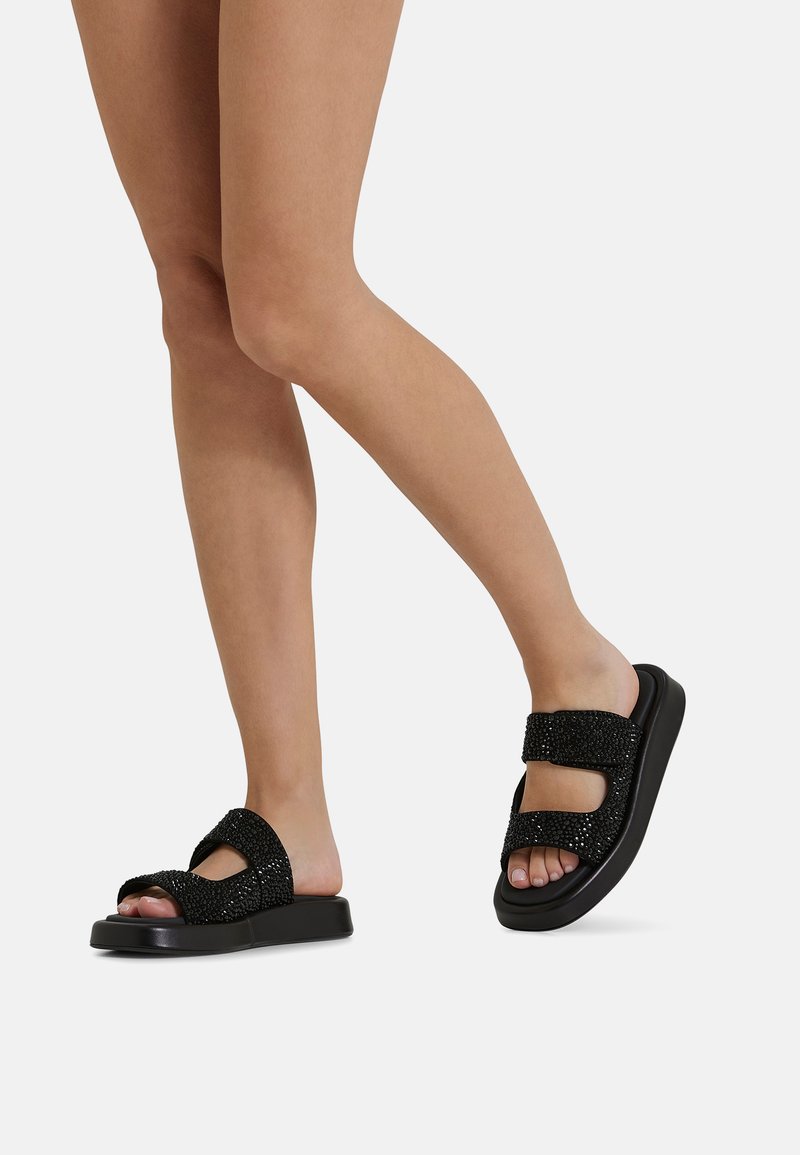 Sandali neri con cinturini testurizzati e dettagli brillanti. Sole piatto, design con punta aperta, chiusure regolabili in velcro per una vestibilità ideale.